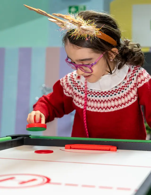 Menina a jogar hockey de mesa.